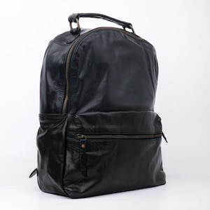 Puede incluir: Una mochila de cuero negro con asa superior y varios compartimentos con cremallera.