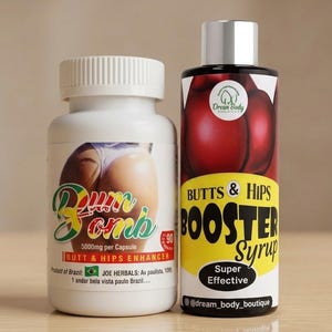 Könnte beinhalten: Zwei Flaschen mit Nahrungsergänzungsmitteln werden gezeigt. Eine ist eine weiße Flasche mit der Aufschrift "Bum Bomb" und einer Gesäßgrafik. Die andere ist eine schwarz-rote Flasche mit der Aufschrift "Butts & Hips Booster Syrup". Beide Flaschen stehen auf einer hellbraunen Oberfläche.