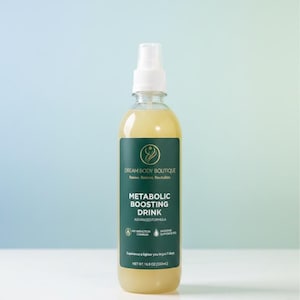 May include: A clear spray bottle filled with a yellow liquid, labeled "Metabolic Boosting Drink" by Dream Body Boutique. The bottle has a green and white label with text and is against a light blue and white background. The net weight is 16.9 oz (500ml).