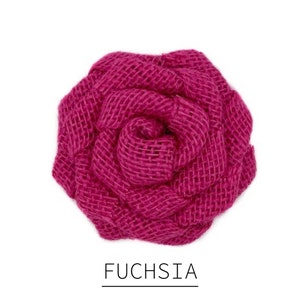 May include: A fuchsia-colored, woven fabric rose. The flower is in full bloom, with tightly woven petals creating a textured appearance. The word "FUCHSIA" is printed in a clean, sans-serif font below the flower.