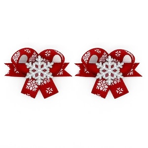 May include: Two red hair bows with white snowflake patterns and silver snowflake embellishments. The bows are made of ribbon and are suitable for holiday or winter themed accessories.