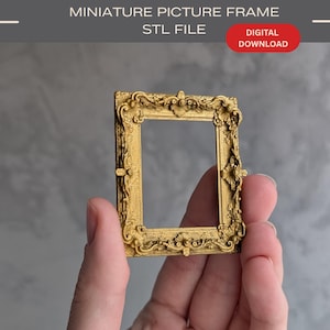 Puede incluir: Un marco de fotos en miniatura de color dorado con intrincados detalles en relieve a lo largo de los bordes. El texto en la parte superior de la imagen dice MINIATURE PICTURE FRAME STL FILE y DIGITAL DOWNLOAD en una insignia ovalada roja.