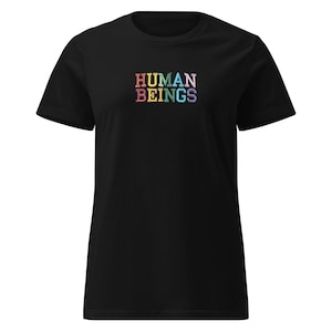Könnte beinhalten: Schwarzes T-Shirt mit dem Text "HUMAN BEINGS" in regenbogenfarbenen Blockbuchstaben auf der Brust. Das Shirt hat kurze Ärmel und einen Rundhalsausschnitt. Der Text ist fett und in einer serifenlosen Schriftart.
