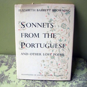 May include: A vintage book titled "Sonnets From The Portuguese" by Elizabeth Barrett Browning. The cover is off-white with floral and scroll designs in light blue and beige. The title is in large, elegant lettering.