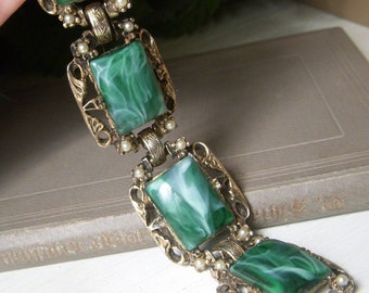 May include: A gold tone bracelet with green and white marbled stones and faux pearl accents.