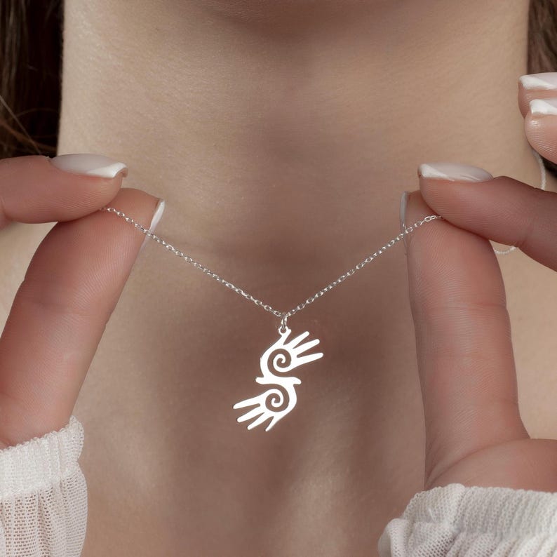Healing Hands Necklace. Crafted from sterling silver, this Hopi hands pendant symbolizes peace, balance, and the power of touch. Featuring two healing hands, this Reiki pendant is a meaningful gift for healers, medical professionals, and spiritual seekers. Whether you’re drawn to its symbolic energy or its artistic beauty, this peaceful charm makes a stunning medical jewelry piece for everyday wear.