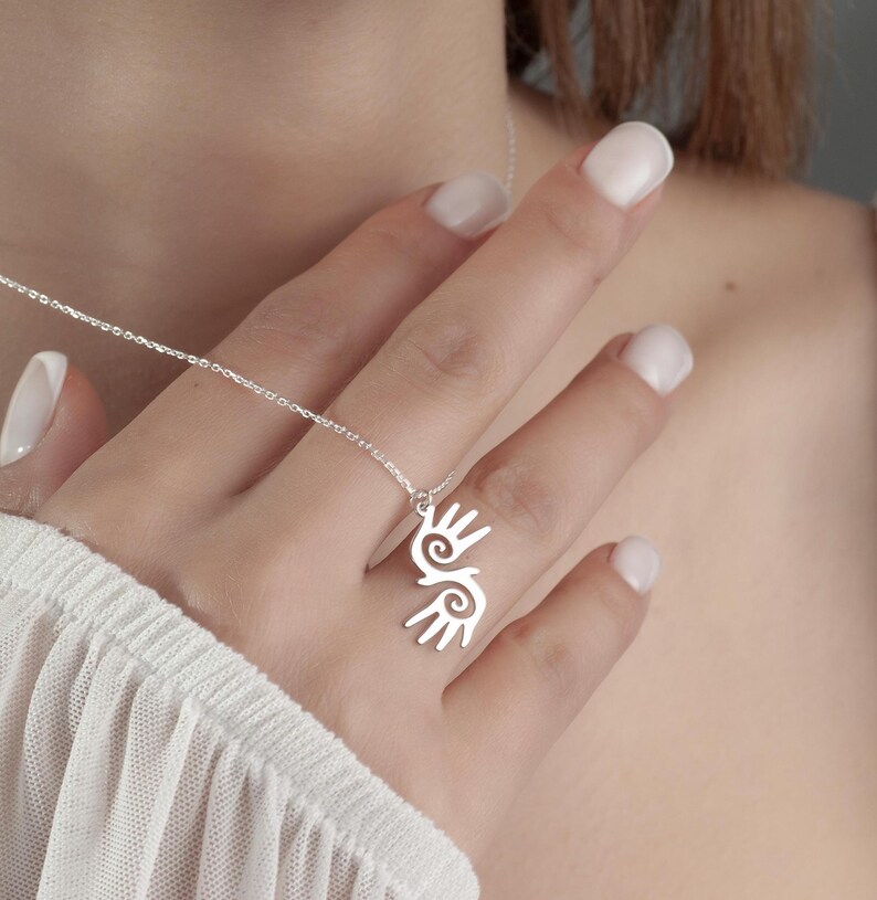 Healing Hands Necklace. Crafted from sterling silver, this Hopi hands pendant symbolizes peace, balance, and the power of touch. Featuring two healing hands, this Reiki pendant is a meaningful gift for healers, medical professionals, and spiritual seekers. Whether you’re drawn to its symbolic energy or its artistic beauty, this peaceful charm makes a stunning medical jewelry piece for everyday wear.