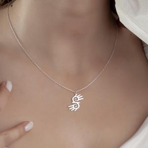 Healing Hands Necklace. Crafted from sterling silver, this Hopi hands pendant symbolizes peace, balance, and the power of touch. Featuring two healing hands, this Reiki pendant is a meaningful gift for healers, medical professionals, and spiritual seekers. Whether you’re drawn to its symbolic energy or its artistic beauty, this peaceful charm makes a stunning medical jewelry piece for everyday wear.