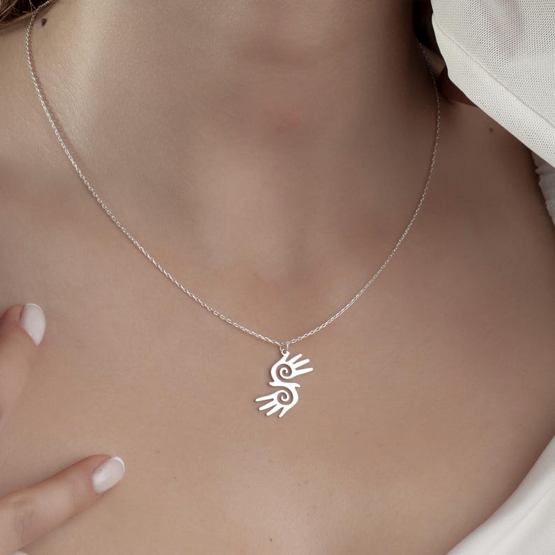 Healing Hands Necklace. Crafted from sterling silver, this Hopi hands pendant symbolizes peace, balance, and the power of touch. Featuring two healing hands, this Reiki pendant is a meaningful gift for healers, medical professionals, and spiritual seekers. Whether you’re drawn to its symbolic energy or its artistic beauty, this peaceful charm makes a stunning medical jewelry piece for everyday wear.