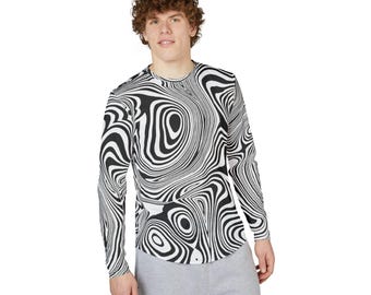 Puede incluir: Una camiseta de manga larga con un patrón de remolino en blanco y negro. El diseño presenta círculos concéntricos y líneas onduladas, creando una ilusión óptica. La camiseta se usa con pantalones de chándal grises.