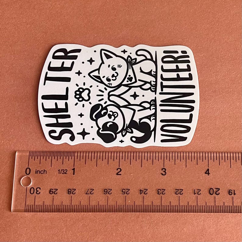 May include: Black and white sticker with a cartoon dog and cat. The sticker says "Shelter Volunteer!"