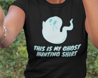 May include: A black t-shirt with a light blue ghost graphic and the text "This is my ghost hunting shirt".