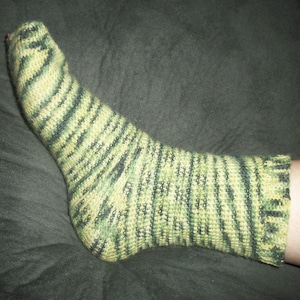 May include: A green and yellow striped sock with a ribbed cuff.