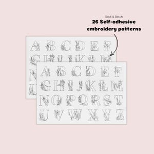 Op de afbeelding: Twee vellen zelfklevende borduurpatronen met het alfabet, waarbij elke letter versierd is met bloemmotieven. De tekst "Stick & Stitch" en "26 Self-adhesive embroidery patterns" is zichtbaar.