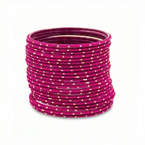 May include: A collection of magenta bangles with a delicate gold dot design. The bangles are stacked, forming a cylindrical shape. The gold dots provide a subtle contrast to the solid magenta colour.