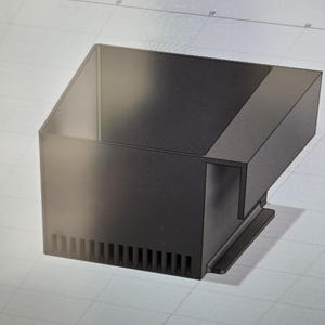 May include: A black, angular, rectangular object with a sloped top and a series of vertical slots along the bottom edge. The design appears to be a 3D rendering or a technical drawing.