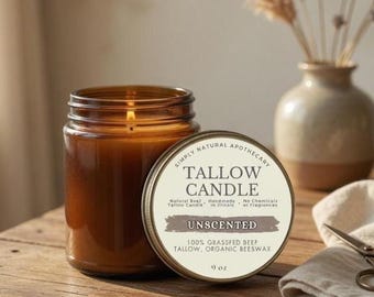 May include: A brown glass jar candle with a lit wick, labeled "TALLOW CANDLE" and "UNSCENTED." The candle is 9 oz and made with grass-fed beef tallow and organic beeswax. The candle sits on a wooden surface.