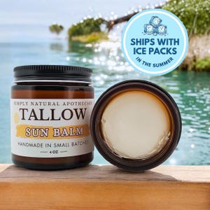 May include: A 4 oz amber glass jar of Simply Natural Apothecary Tallow Sun Balm with a black lid, featuring a white label with black and yellow text. Beside it, an open jar reveals a smooth, off-white balm. A circular blue sticker notes ice packs.