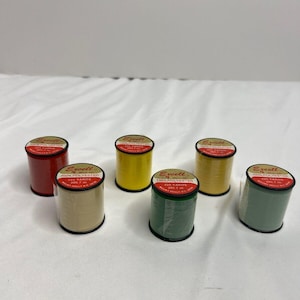 May include: Six spools of thread in various colors, including red, yellow, green, and beige. Each spool is labeled "Excell" and "100% Polyester" with the yardage listed.