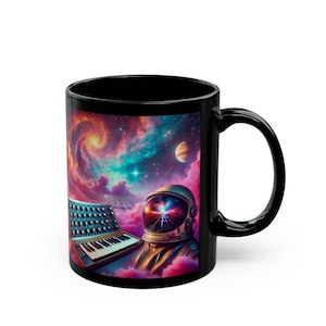 May include: Black coffee mug with a colorful galaxy scene featuring a retro synthesizer, an astronaut with a glowing nebula inside their helmet, and a planet.