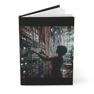 May include: A silhouette of a person working in a server room with a lot of wires and cables. The person is wearing a dark shirt and has their back to the camera. The server room is lit with a blue and green light.