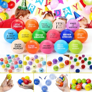 May include: A collection of colorful stress balls with motivational phrases like "Stay Positive" and "You're Amazing!" Various sizes and designs, including smiley faces, are shown. Party decorations are in the background.