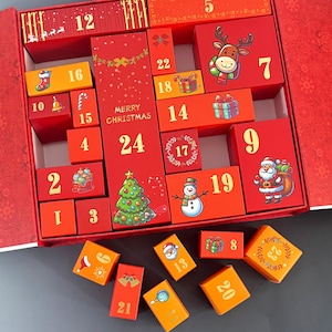 May include: A red Christmas advent calendar with numbered boxes, featuring festive illustrations like a reindeer, snowman, and Santa Claus. The calendar includes the text "Merry Christmas" and is designed to count down the days until Christmas.
