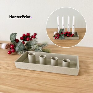 May include: A rectangular, pale grey candle holder with four cylindrical openings. The image also shows a circular inset with four white candles, each numbered, and decorated with red berries and greenery. The text "HonterPrint." is in the upper left.