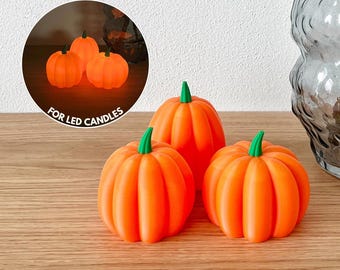 May include: Orange pumpkin decorations with green stems. The pumpkins are arranged on a wooden surface. The text "FOR LED CANDLES" is visible in a circular graphic with smaller pumpkins.