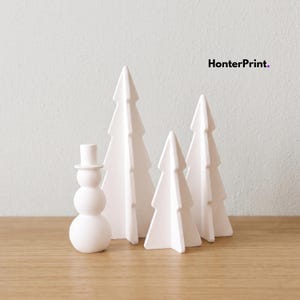 May include: A set of white matte decorative figures including a snowman and three stylized pine trees of varying heights. The figures are arranged together, and the text HonterPrint is visible in the upper right corner of the image.