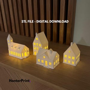 Könnte beinhalten: Vier weiße Keramikhäuser mit ausgeschnittenen Fenstern, von innen beleuchtet, auf einer Holzoberfläche. Der Text "STL FILE - DIGITAL DOWNLOAD" wird über den Häusern angezeigt.