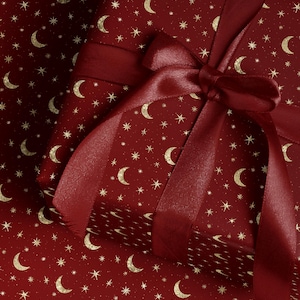 Celestial moon and star wrapping paper with gold design in burgundy