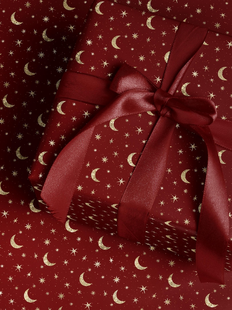 Celestial moon and star wrapping paper with gold design in burgundy