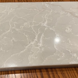 May include: A white rectangular countertop with a light gray veining pattern.