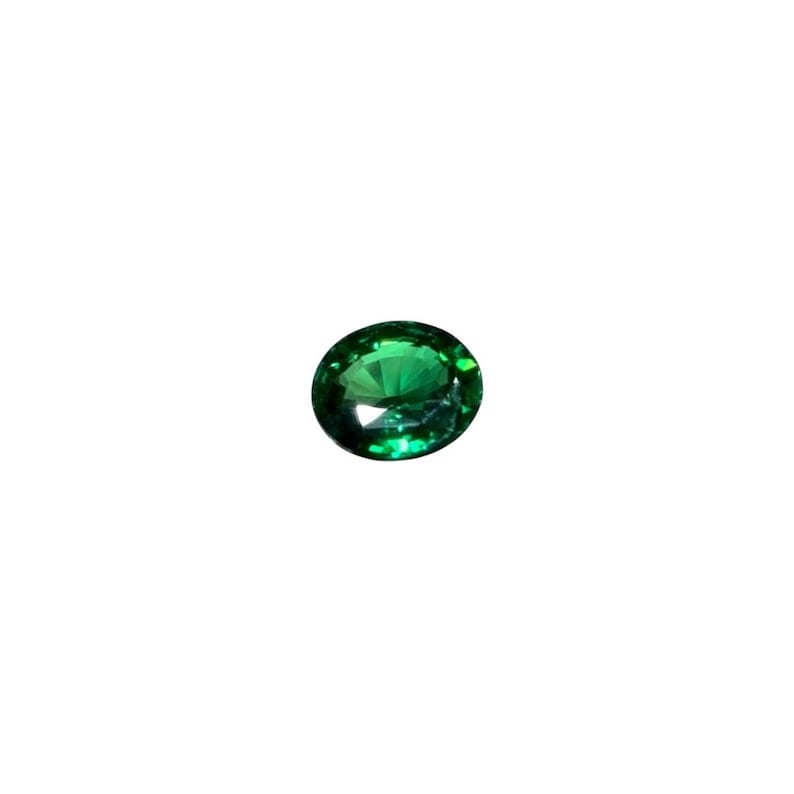 May include: A vibrant, oval-cut emerald gemstone. The gem is a deep, rich green color with facets that catch the light, creating a sparkling effect. The gemstone is set against a plain white background.