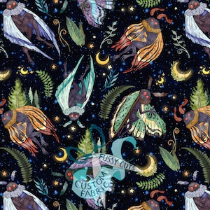 May include: A black fabric pattern featuring moth-like creatures with red eyes, colorful wings, crescent moons, stars, and green ferns. A teal ribbon graphic with the text FUSSY CUTS CUSTOM FABRIC is overlaid in the center of the repeating design.