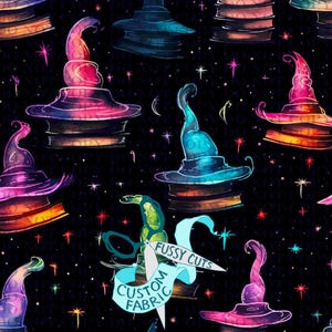 May include: A repeating pattern of colorful witch hats, books, stars, and crescent moons on a black background. The hats are in shades of pink, blue, purple, and orange. The text "FUSSY CUTS" and "CUSTOM FABRIC" is visible.