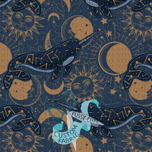 May include: A dark blue fabric featuring a repeating pattern of narwhals with gold constellation markings, suns with faces, and crescent moons. A light blue ribbon overlay in the center displays the text FUSSY CUTS CUSTOM FABRIC.