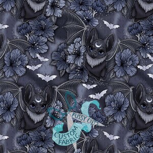 May include: A repeating pattern featuring stylized bats with crescent moon markings, surrounded by dark blue flowers and small white bats. The background is a mottled dark blue with white speckles. The image has the text "Fussy Cuts Custom Fabric".