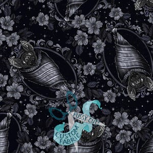 Peut inclure: Un tissu noir avec un motif répétitif de chauves-souris enveloppées dans des couvertures rayées, chacune encadrée par une bordure ovale ornée. Le fond est rempli de motifs floraux gris et de petites étoiles blanches. Un filigrane indique FUSSY CUTS CUSTOM FABRIC.