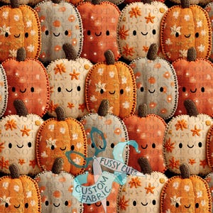 Peut inclure: Un motif répétitif de citrouilles en tissu dans des tons orange, crème et gris. Chaque citrouille présente une tige cousue, un visage souriant brodé simple et divers motifs floraux ou à pois. Un filigrane avec des ciseaux et du texte est visible.