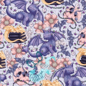 May include: A repeating pattern featuring whimsical purple dragons with large wings, surrounded by pink flowers, bats, skulls, and crystals on a light blue background. The design includes the text "FUSSY CUTS CUSTOM FABRIC".