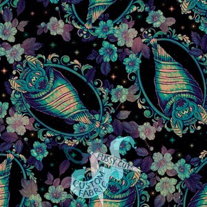 Peut inclure: Un tissu noir avec un motif répétitif de chauves-souris enveloppées dans des couvertures, encadrées par des bordures ovales bleu sarcelle ornées et entourées de fleurs violettes et bleu sarcelle et de petites étoiles. Une bannière blanche porte le texte FUSSY CUTS CUSTOM FABRIC.
