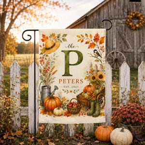 May include: A decorative garden flag featuring a large green letter P, the text "the PETERS EST. 2025", a straw hat, a metal watering can, pumpkins, a wooden cart, a basket of apples, green boots, and autumn foliage on a cream-colored background.