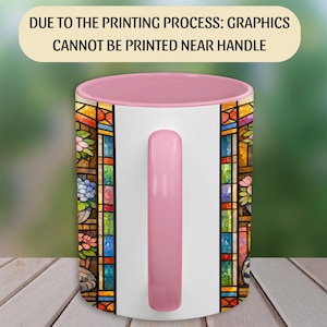Puede incluir: Una taza de cer&aacute;mica blanca con interior y asa rosas. La taza presenta un dise&ntilde;o de vidriera con patrones florales y geom&eacute;tricos en varios colores. El texto en la parte superior dice: DUE TO THE PRINTING PROCESS: GRAPHICS CANNOT BE PRINTED NEAR HANDLE.
