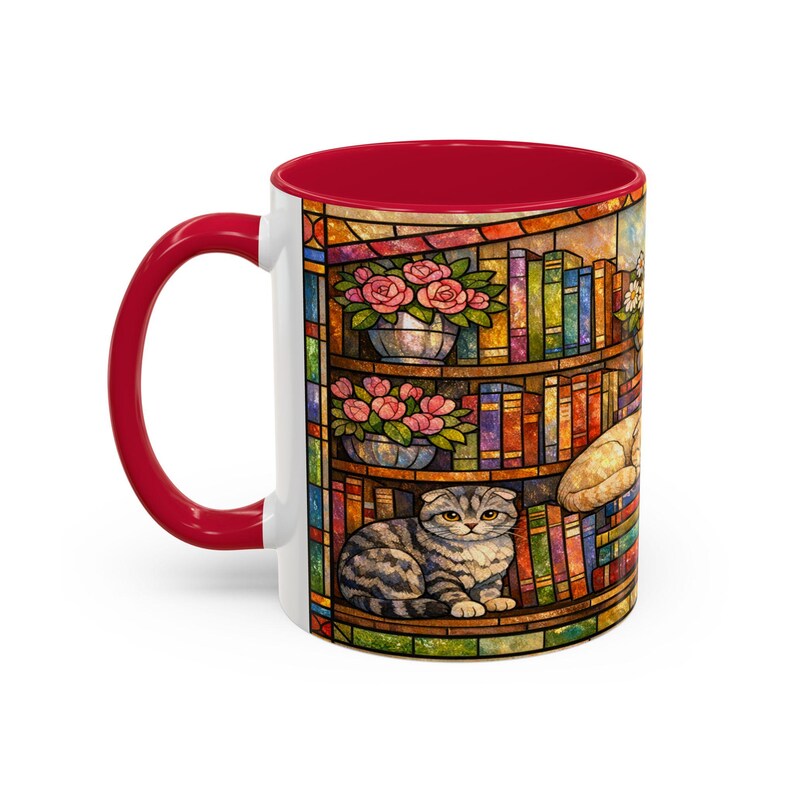 Puede incluir: Taza de cer&aacute;mica blanca con interior y asa rojos. La taza presenta un colorido dise&ntilde;o de vidriera de una estanter&iacute;a con libros, rosas rosas y un gato atigrado gris. La taza es de tama&ntilde;o est&aacute;ndar.