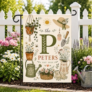 May include: A rectangular garden flag featuring a large green letter P and the text the PETERS EST. 2025. The design includes illustrations of a hanging plant, a straw hat, a trowel, a watering can, a pitcher, a basket of flowers, and a bee.