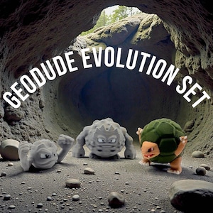 May include: A set of three 3D-printed Geodude Evolution figures. The figures are in a cave setting, with the text "GEODUDE EVOLUTION SET" above them. The figures are gray and green, with detailed textures and expressions.