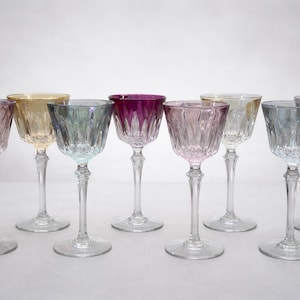 Peut inclure: Ensemble de huit verres à vin colorés. Les verres ont des tiges longues et transparentes et des bols texturés dans des tons de rose, jaune, vert et violet.