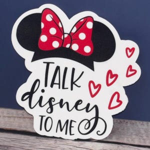 May include: White sticker with a black and red Minnie Mouse head, a red bow with white polka dots, and the text "TALK disney TO ME" in black cursive lettering. There are four red hearts around the text.